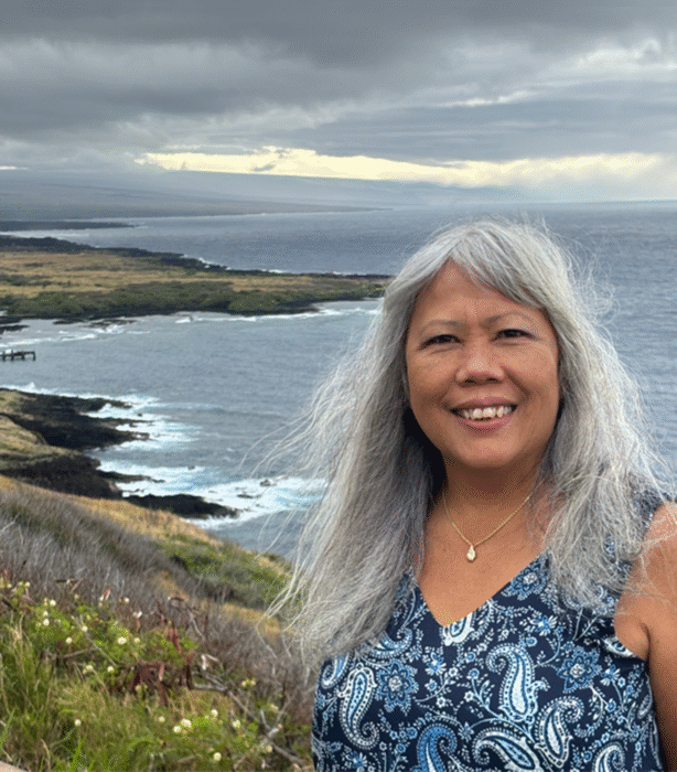 author photo of Darlene Javar against landscape backdrop, cliffs of Kaʻu
